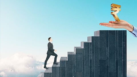 Businessman climbing staircase towards a golden rupee symbol held by a hand, symbolising financial growth, success and career progress