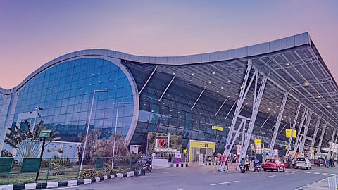 Thiruvananthapuram International Airport terminal building with modern glass façade and passenger entry area at sunset