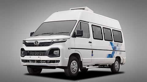 White Tata Winger van with modern design and blue graphic pattern, front and side view on grey background.