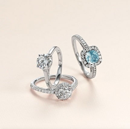 L-R: Lab diamond round diamond solitaire. Lab diamond round diamond halo with lab diamond accents. Aquamarine cushion halo with lab diamond accents