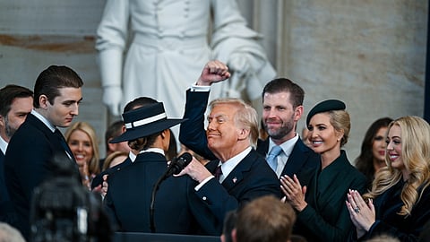 Rodeado pela família, com a mão esquerda no ombro da mulher, Melania, Donald Trump festeja após ter jurado cumprir a Constituição dos EUA.
