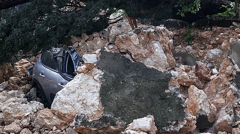 Um carro desfeito plea queda de um muro na Tapada das Necessidades