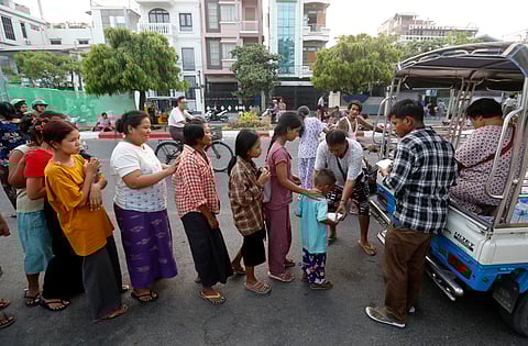 Voluntários locais distribuem alimentos e água em Mandalay.