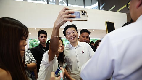 O primeiro-ministro de Singapura e secretário-geral do Partido de Ação Popular, Lawrence Wong, tira selfies com apoiantes durante a campanha.