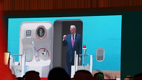 Sauditas assistem na televisão à chegada de Trump, a bordo do atual Air Force One.