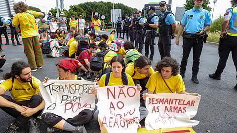 Os manifestantes sentados faixa rodoviária.