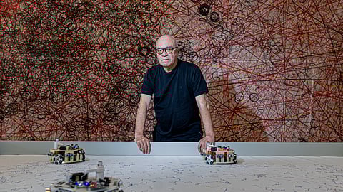 Leonel Moura junto dos seus robôs que criam pinturas ao vivo, no Técnico Innovation Center, em Lisboa.  