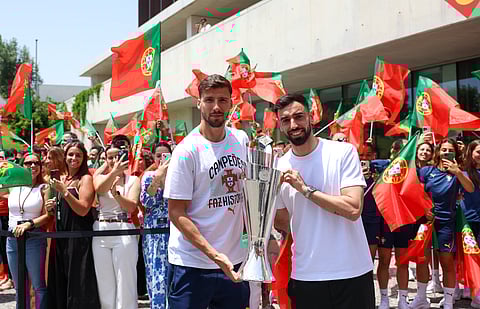 Rúben Dias e Bruno Fernandes exibem a taça à chegada à Cidade do Futebol
