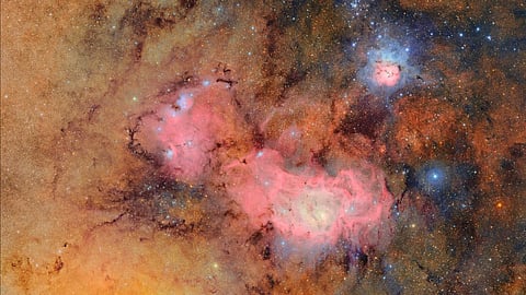 Na Constelação de Sagitário, o telescópio fotografou duas nebulosas (Trífide, em cima, com contornos azuis, e Lagoa, ao centro).