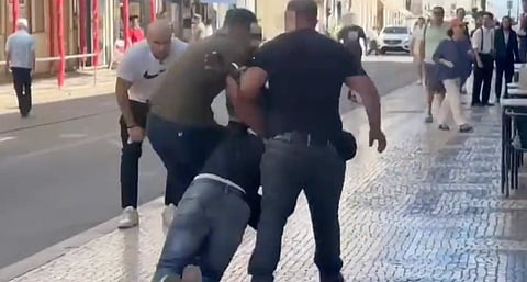 Agentes à paisana da Polícia Municipal de Lisboa a arrastar, algemado, um homem suspeito de venda ambulante ilegal - uma contra-ordenação. Imagem de uma das reportagens do canal Now que levaram o MP a abrir inquérito criminal. 