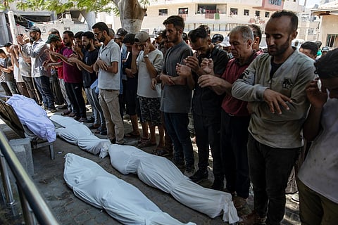 Este domingo, palestinianos rezaram sobre os corpos de pessoas que foram mortas a tiro num ponto de distribuição de alimentos.