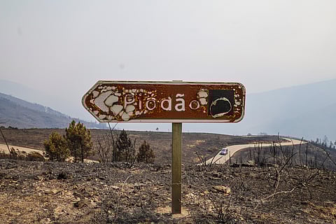 Uma placa a indicar Piódão, queimada.