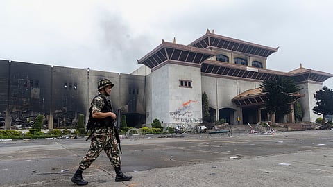 Soldado em patrulha frente ao destruído edifício do Parlamento.
