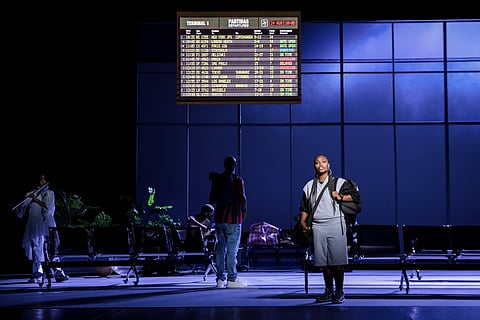 A ópera está dividida em cinco atos e passa-se no Aeroporto de Lisboa.