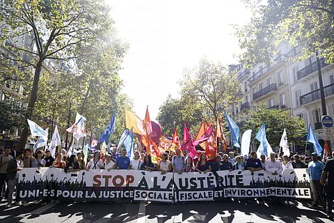 Membros de vários sindicatos caminham atrás de uma faixa com as palavras "Parem a austeridade" numa manifestação esta quinta-feira em Paris.