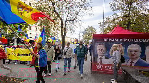 Apoiantes do PAS passam pela campanha do Bloco Patriótico no centro de Chisinau.