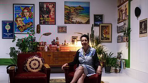 Zineb Sedira sentada num cadeirão que trouxe da sua casa de Brixton. A sua sala de estar “completamente 60s”, foi recriada em Lisboa. 