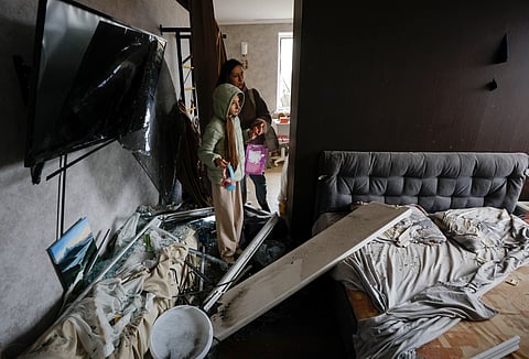 Liya, de 11 anos, e a mãe, Hanna, 32, observam danos na sua casa em Kiev na sequência de ataque russo no dia 28 de setembro. 
