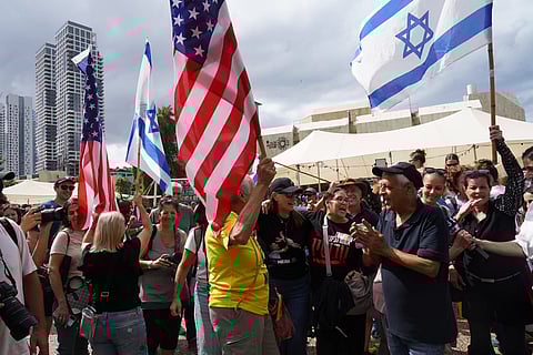 Bandeiras dos EUA ao lado das de Israel nos festejos na Praça dos Reféns, em Telavive. 