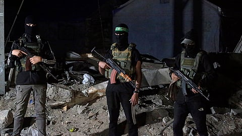 Membros das Brigadas al-Qassam, braço armado do Hamas, de guarda aos veículos da Cruz Vermelha que transportaram dois corpos de reféns israelitas.