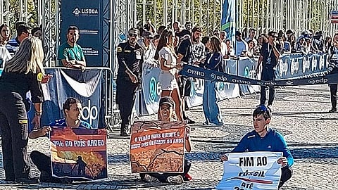 Apoiantes do Climáximo sentam-se junto à meta da Meia Maratona de Lisboa