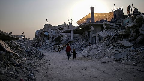 Duas crianças passeiam entre ruínas em Jabalia, no norte de Gaza.