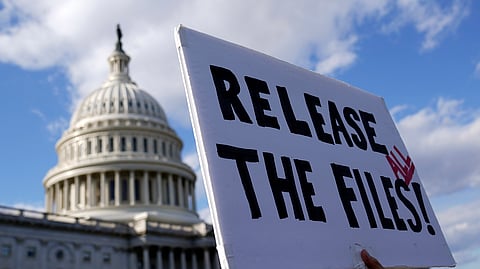 Manifestante com um cartaz, diante do Capitólio, a pedir a divulgação de todos os ficheiros sobre Epstein.