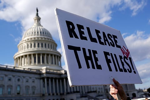 Manifestante com um cartaz, diante do Capitólio, a pedir a divulgação de todos os ficheiros sobre Epstein.