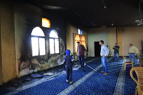 Locais inspecionam os danos na mesquita Hamida após um ataque de colonos israelitas na quinta-feira.