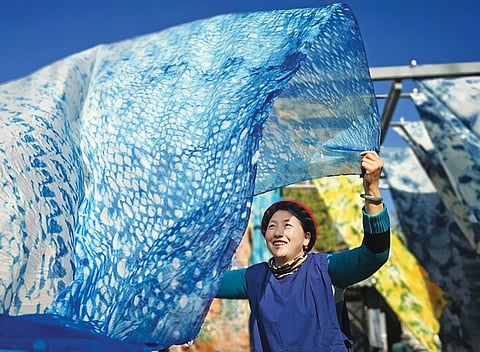Tecidos tingidos secando ao sol.