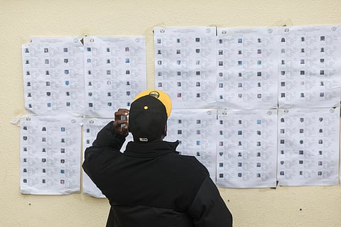 Um cidadão guineense consulta cadernos eleitorais antes de votar na embaixada em Lisboa, no domingo.