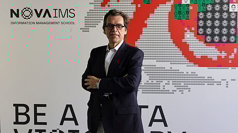 Miguel de Castro Neto fotografado frente à nova imagem da Nova IMS: os "Data Visionaries".