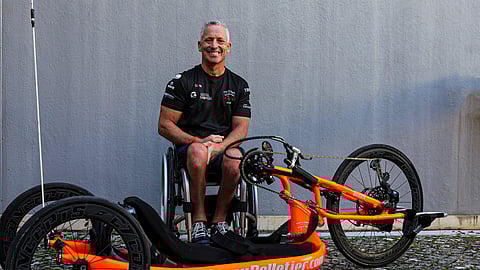 Jimmy junto à sua bicicleta onde se podem ver as bandeiras do Canadá e do Quebeque.
