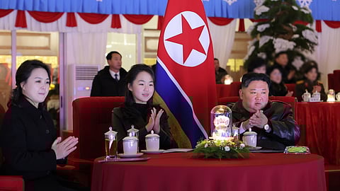 Kim Ju-ae ladeada pela mãe, Ri Sol-ju, e pelo pai, Kim Jong-un.