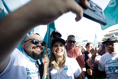 A favorita Laura Fernández, que é apoiada pelo presidente, tira uma selfie com um apoiante na campanha.