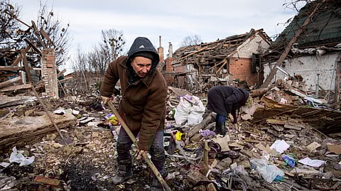 Residentes limpam o local de um ataque russo na região de Donetsk.