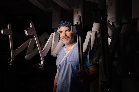 O médico David Subirá com os braços robóticos que permitem uma cirurgia de alta precisão.