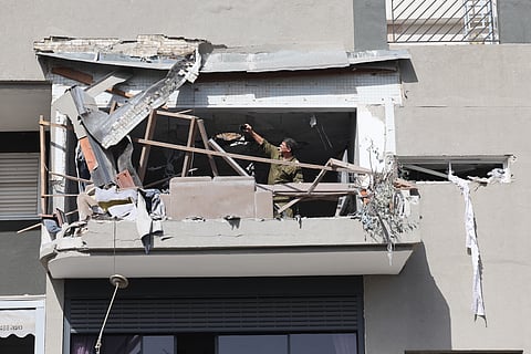 Um soldado israelita documenta os estragos de um míssil iraniano que matou um casal em Ramat Gan, a leste de Telavive.