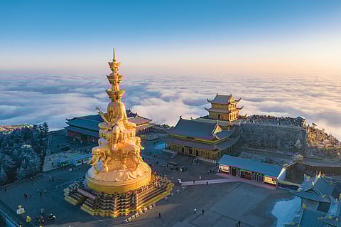Ao nascer do dia, no Pico Dourado, a Estátua de Samantabhadra das Dez Direções ergue-se acima das nuvens.