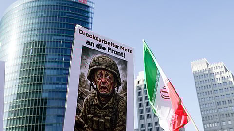 Chanceler Merz representado em cartoon numa manifestação em Berlim contra a guerra no Irão.