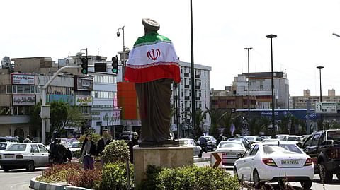 Bandeira iraniana colocada à volta de uma estátua em Teerão, na manhã seguinte ao anúncio do cessar-fogo de duas semanas entre EUA e Irão.