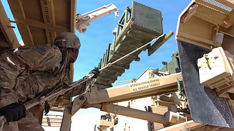 Um artilheiro do Exército dos EUA recarrega um lançador de mísseis MIM-104 Patriot num local não revelado.