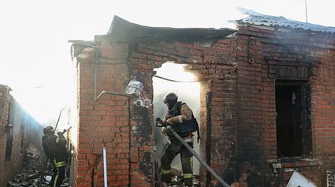 Equipas de resgate ucranianas trabalham no local de um ataque russo a um edifício privado em Kharkiv.