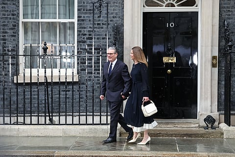 Keir Starmer com a mulher, Victoria, à saída do número 10 de Downing Street, no dia do Discurso do Rei. 