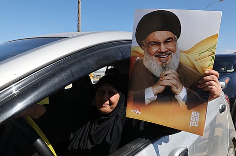 Uma mulher com uma foto de Hassan Nasrallah, o líder do Hezbollah que foi morto por Israel em setembro de 2024.