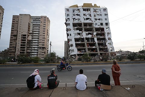 Venezuelanos olham para um edifício danificado pelo duplo sismo de dia 24 de junho.