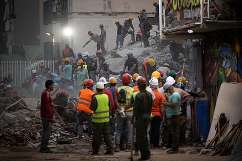 As equipas de resgate realizam uma operação de busca e salvamento num edifício danificado pelos sismos em Caracas.