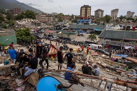 Pessoas à volta de um edifício colapsado em La Guaira.