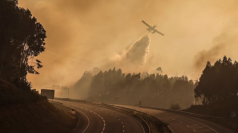 Um avião de apoio aos bombeiros lança água junto à autoestrada A25 (uma das Scut) que esteve encerrada devido ao grande incêndio que começou em Vouzela e se propagou a concelhos limítrofes. 4 de julho de 2026.