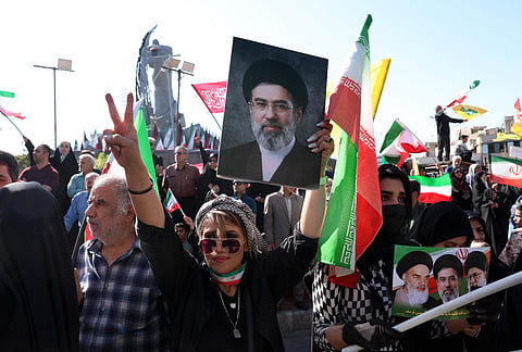 Uma mulher iraniana segura uma fotografia do Líder Supremo do Irão, ayatollah Mojtaba Khamenei.